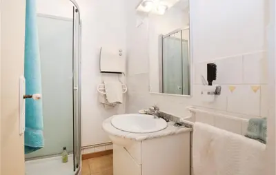 a white bathroom with a sink and a shower at Pet Friendly Apartment in Pianottoli-Caldarello