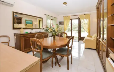 a kitchen and dining room with a wooden table and chairs at Pet Friendly Apartment in Pianottoli-Caldarello