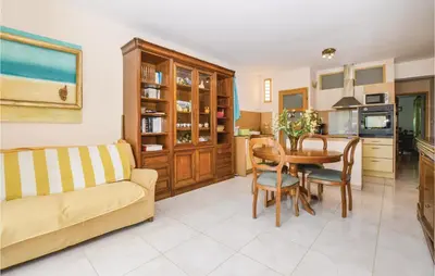 a living room with a couch and a table at Pet Friendly Apartment in Pianottoli-Caldarello