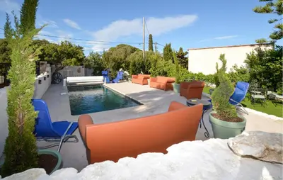 a patio with chairs and a pool in a yard at Pet Friendly Apartment in Pianottoli-Caldarello