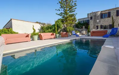 a swimming pool with orange furniture and blue chairs at Pet Friendly Apartment in Pianottoli-Caldarello