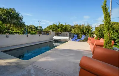 a swimming pool in a backyard with chairs and trees at Pet Friendly Apartment in Pianottoli-Caldarello