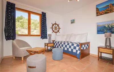 a bedroom with a bed and a chair and a window at Beautiful Home In Porto Vecchio in Porto-Vecchio