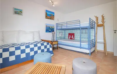 a bedroom with two bunk beds and a table at Beautiful Home In Porto Vecchio in Porto-Vecchio