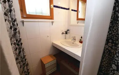 a small bathroom with a sink and a mirror at Beautiful Home In Porto Vecchio in Porto-Vecchio
