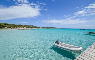 a boat sitting on the water next to a dock at Beautiful Home In Porto Vecchio in Porto-Vecchio