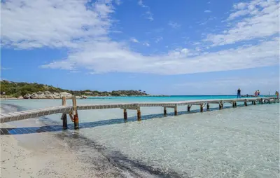 a pier sticking out of the water on a beach at Beautiful Home In Porto Vecchio in Porto-Vecchio
