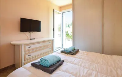a bedroom with a bed with two pillows and a television at Awesome Home In Borgo in Borgo