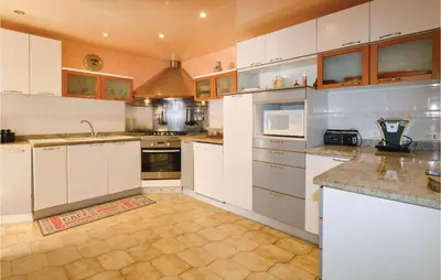 a large kitchen with white cabinets and white appliances at Awesome Home In Borgo in Borgo
