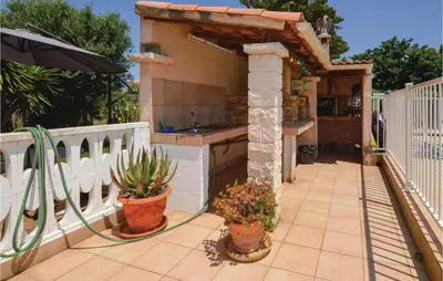 a patio with potted plants and an outdoor kitchen at Awesome Home In Borgo in Borgo