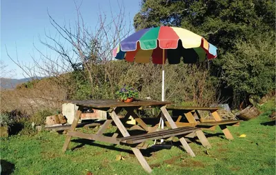 a picnic table with an umbrella in a field at Lovely Stacaravan In Casalabriva in Casalabriva