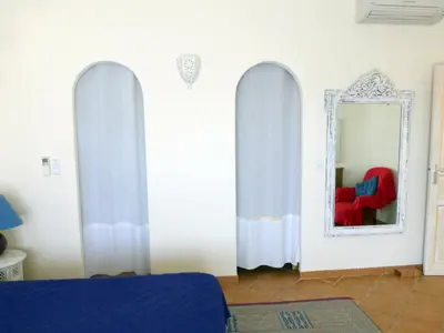 a room with a mirror and a red chair at CAEDA in Porto-Vecchio