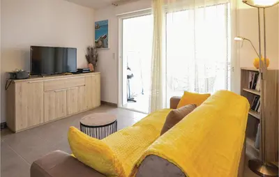 a living room with a yellow couch and a tv at Gorgeous Apartment In Ajaccio With Wifi in Ajaccio