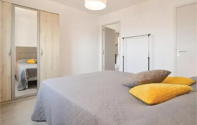 a bedroom with a large bed with yellow pillows at Gorgeous Apartment In Ajaccio With Wifi in Ajaccio