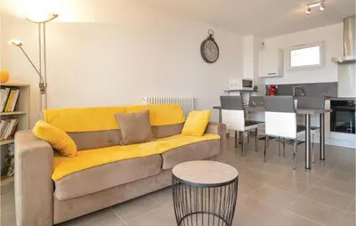 a living room with a yellow couch and a kitchen at Gorgeous Apartment In Ajaccio With Wifi in Ajaccio