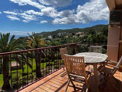 a patio with a table and chairs on a balcony at Cardellini 10- vue mer-piscine en résidence in Sari Solenzara