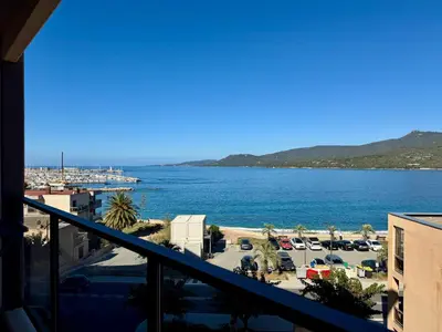 a view of a body of water from a balcony at Appartement neuf tout confort en bord de mer in Propriano