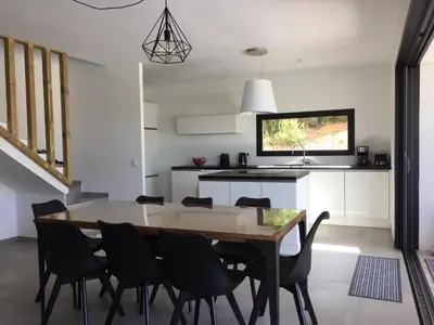a kitchen and dining room with a table and chairs at Villa Mamago in Cirendinu