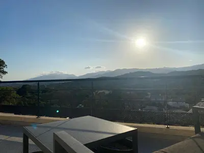 a table on a balcony with a view of the mountains at Villa Mamago in Cirendinu