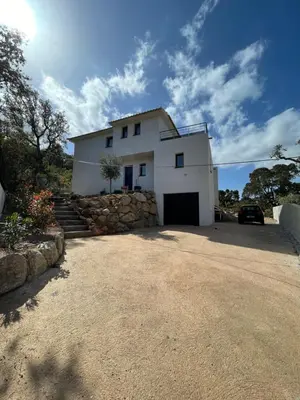 a white house with a car parked in the driveway at Villa Mamago in Cirendinu