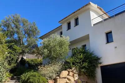 a white house with trees and bushes at Villa Mamago in Cirendinu