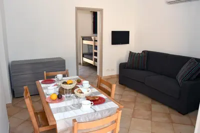 a living room with a table and a couch at Résidence Cala Bianca in Borgo