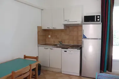 a small kitchen with a sink and a refrigerator at Résidence Cala Bianca in Borgo