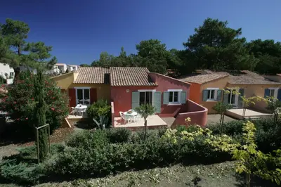 a house in the middle of a garden at Résidence Cala Bianca in Borgo