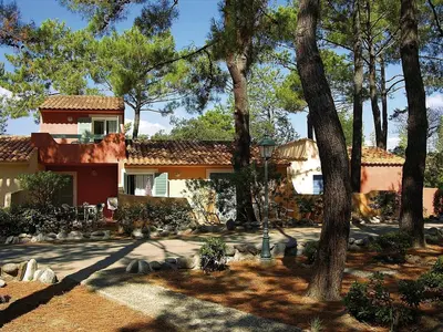a house with trees in front of a yard at Résidence Cala Bianca in Borgo