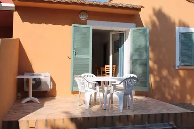 a patio with a table and chairs on a porch at Résidence Cala Bianca in Borgo