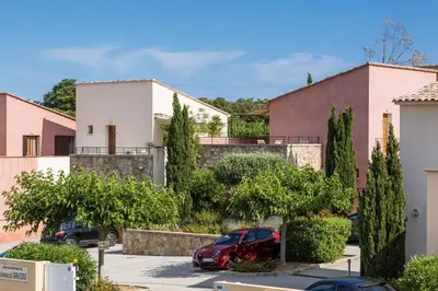 a car parked in a parking lot in front of houses at Résidence Odalys Les Hameaux de Capra Scorsa in Belgodère