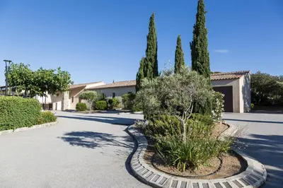 a driveway with trees and bushes in a house at Résidence Odalys Les Hameaux de Capra Scorsa in Belgodère