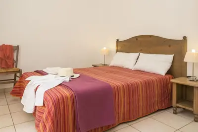 a bedroom with a bed with a hat on it at Résidence Odalys Les Hameaux de Capra Scorsa in Belgodère