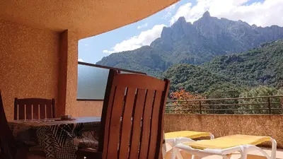 a bedroom with a bed and a table and a window at Résidence A Barcella in Porto Ota