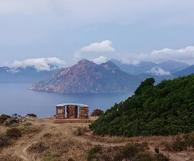 a building on top of a hill with a view of the ocean at Résidence A Barcella in Porto Ota