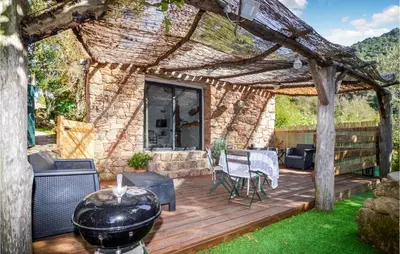 a wooden deck with a pergola and a grill at Amazing Home In Coti-Chiavari in Coti-Chiavari