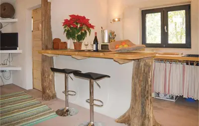 a kitchen with a wooden counter with stools under it at Amazing Home In Coti-Chiavari in Coti-Chiavari