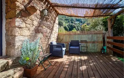 a patio with a grill and chairs on a wooden deck at Amazing Home In Coti-Chiavari in Coti-Chiavari