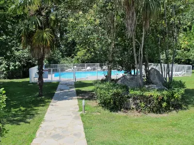 a path in a park with a swimming pool at Holiday Home A Suara-2 by Interhome in Ghisonaccia