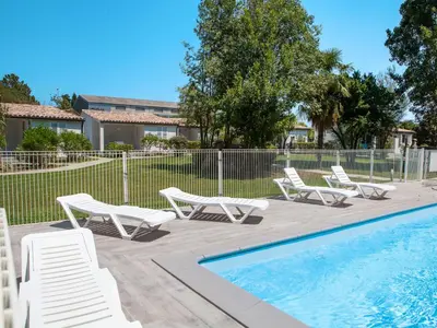 a group of lounge chairs and a swimming pool at Holiday Home A Suara-2 by Interhome in Ghisonaccia