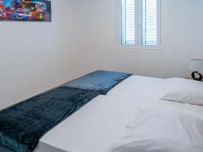 a white bed with a blue blanket on top of it at Holiday Home A Suara-2 by Interhome in Ghisonaccia
