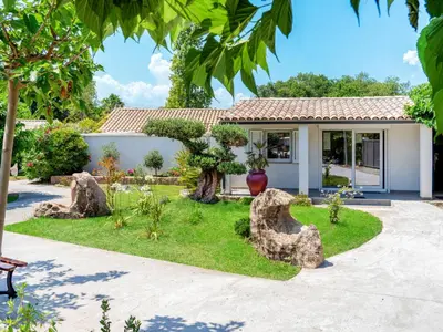 a garden with rocks in front of a house at Holiday Home A Suara-2 by Interhome in Ghisonaccia