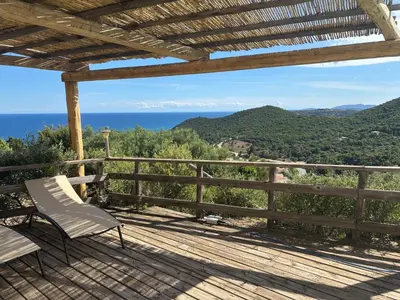a deck with a bench and a view of the ocean at CAROLE F3 in Sainte-Lucie de Porto-Vecchio