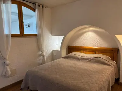 a bedroom with a bed and a window at CAROLE F3 in Sainte-Lucie de Porto-Vecchio