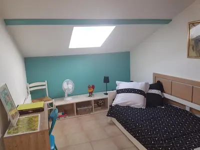 a bedroom with a bed and a blue wall at Domaine de Mélody in Moriani Plage