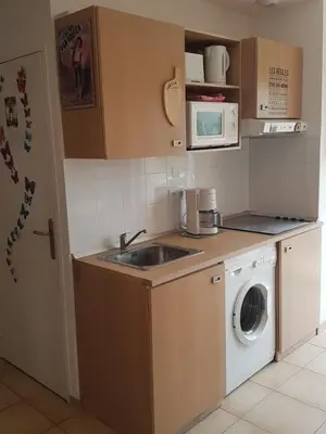 a kitchen with a sink and a washing machine at Domaine de Mélody in Moriani Plage