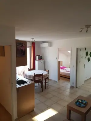 a kitchen and a living room with a table at Domaine de Mélody in Moriani Plage