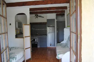 a kitchen with two beds and a ceiling fan at Suarella in Propriano