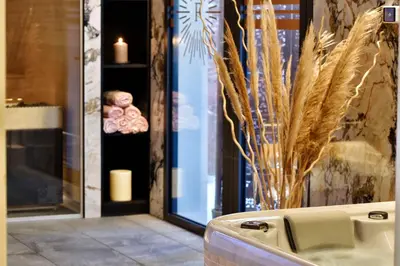 a bathroom with a bath tub with a vase of candles at Hôtel Fesch & Spa in Ajaccio