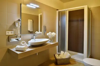 a bathroom with a sink and a toilet and a mirror at Hôtel Fesch & Spa in Ajaccio